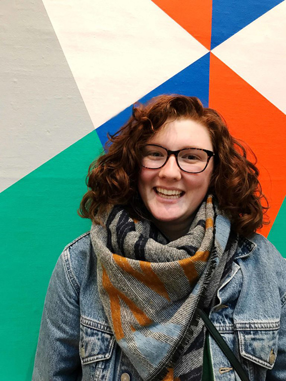 A happy lady in a scarf and jean jacket